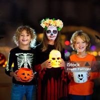 Dia de los muertos celebration. Traditional Day of the Dead party. Halloween in Mexico. Mexican girl in traditional make up and Catrina costume with a scull.